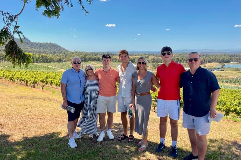 Two British families enjoying a private Hunter Valley wine tour at Audrey Wilkinson Estate under a vivid blue sky.